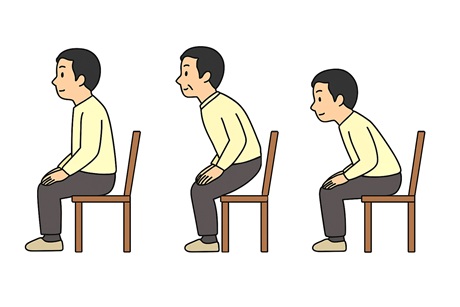 椅子に座って腰を浮かせてスクワットをする男性